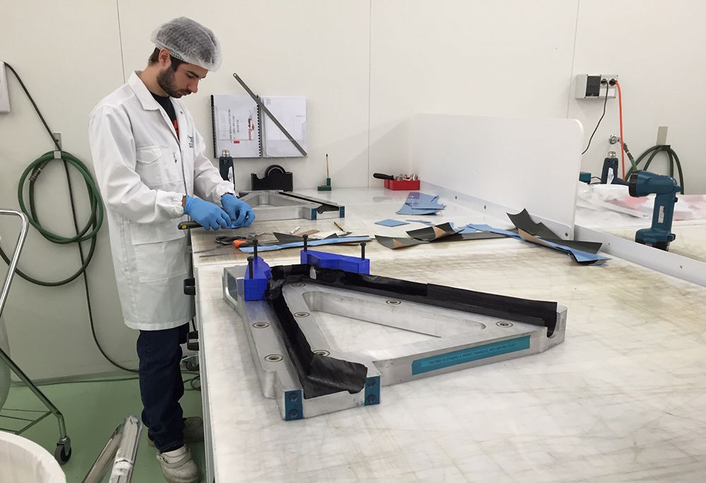 Technician laying up carbon plies in a frame mould